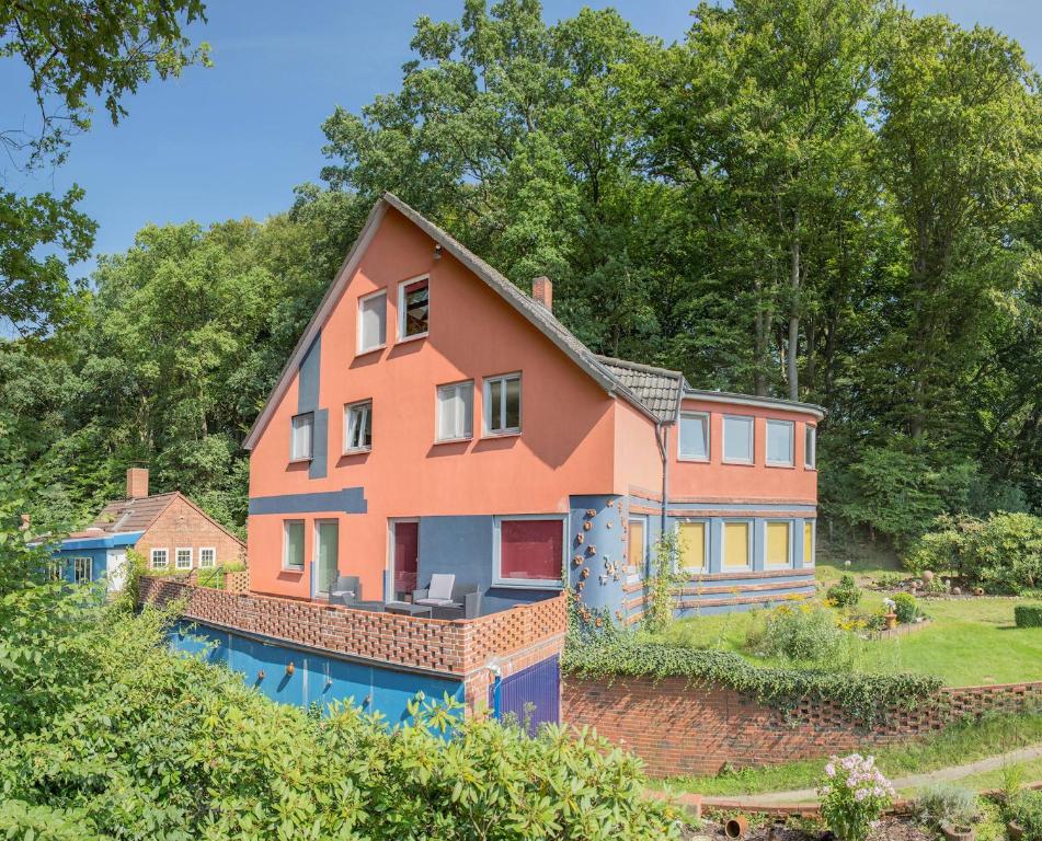 ein großes orangefarbenes Haus mit Pool im Hof in der Unterkunft Willi Ohler Haus in Worpswede