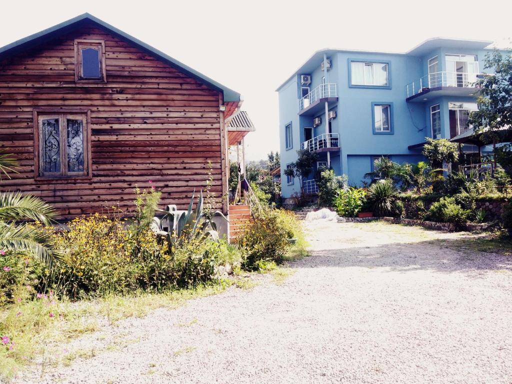 a small wooden building next to a house at Wooden Cottage in Makhinjauri