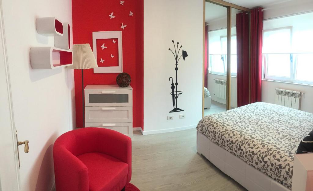 1 dormitorio rojo con 1 cama y 1 silla roja en Apartamento Centro Frente Muralla, en Lugo
