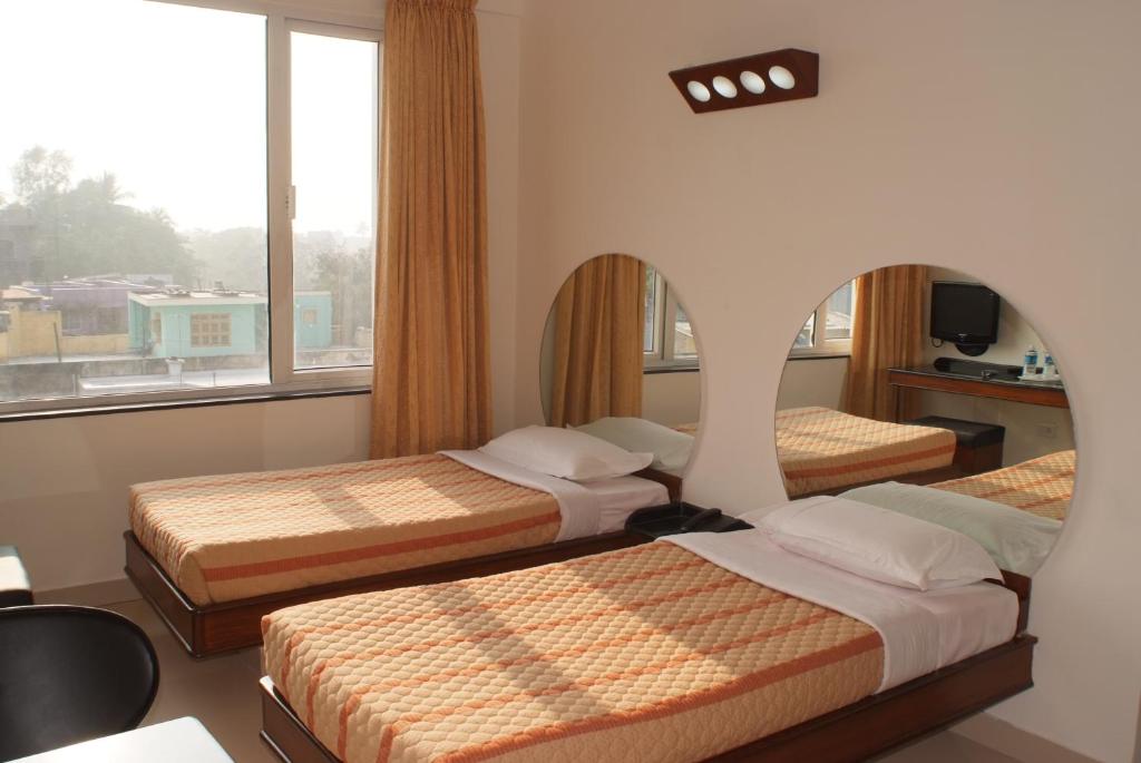 Voodi või voodid majutusasutuse Lotus Comfort - A Pondy Hotel toas