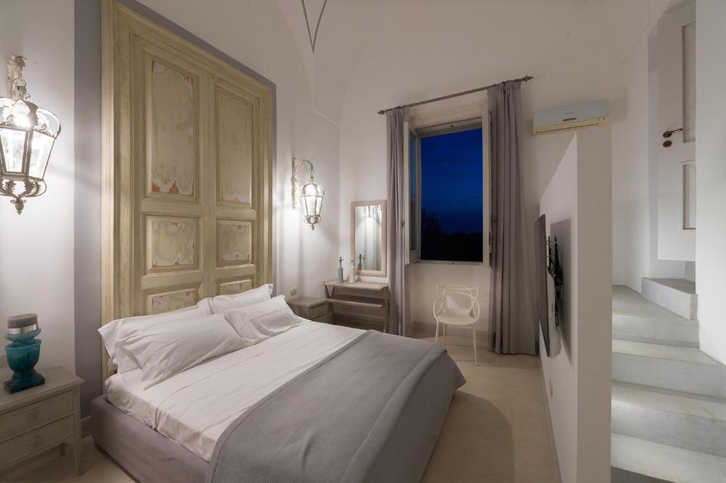 サンニコーラにあるVilla Starace - Appartamento Buongiornoの白いベッドルーム(ベッド1台、窓付)
