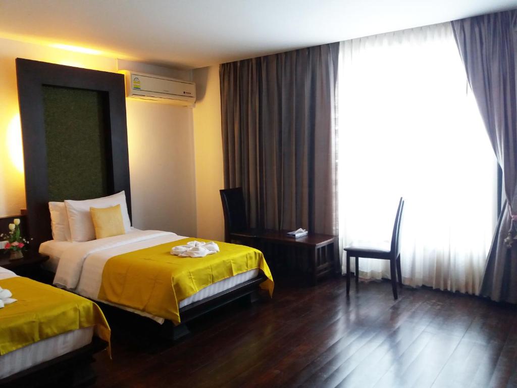 Postel nebo postele na pokoji v ubytování Nicha Suite Hua Hin Hotel