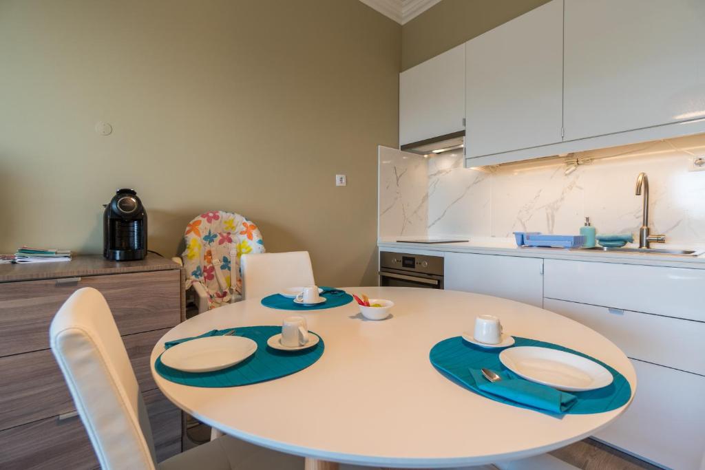 a kitchen with a white table with chairs and a kitchen at Beach House Ericeira in Ericeira