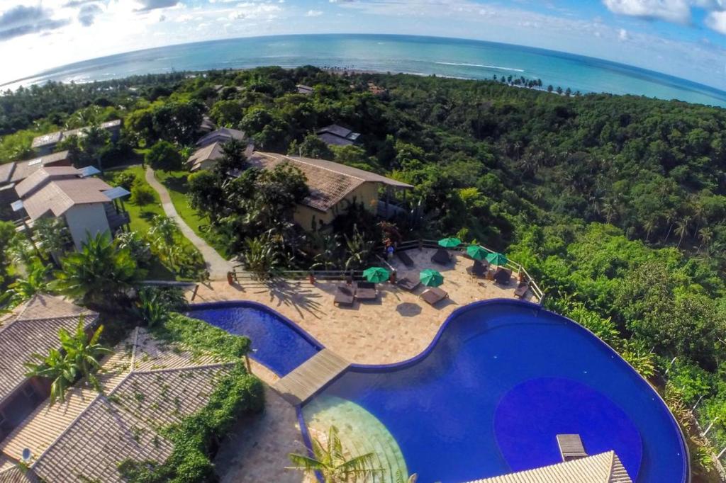 an aerial view of a house with a swimming pool and the ocean at Villas do Pratagy Acerola in Maceió