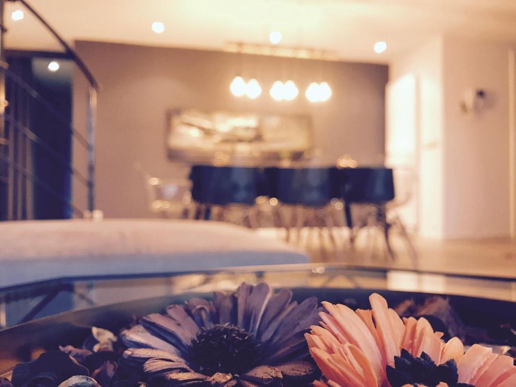a bowl of flowers on a table in a room at Modern Loft Duplex Penthouse Free parking in Brussels