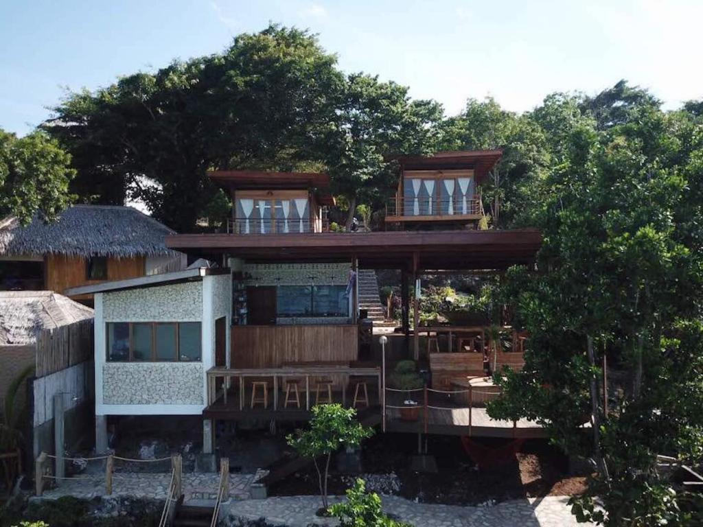 a large house with a balcony and trees at Tevana House Reef in Bira