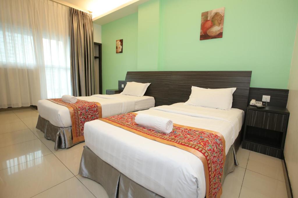 Postel nebo postele na pokoji v ubytování Ipoh Downtown Hotel