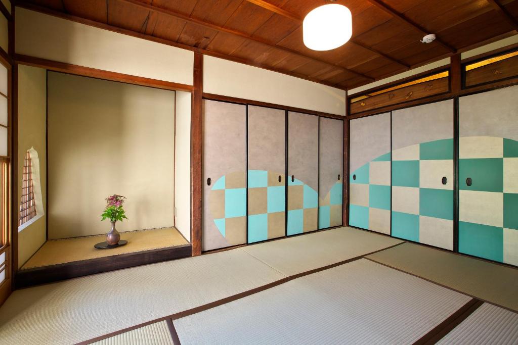 京都画廊诺泽酒店 的一间日式客房,墙上挂有绘画作品