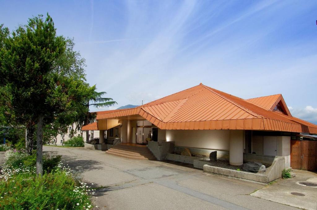 a building with an orange roof on a street at Wisterian Life Club Nojiriko in Shinano