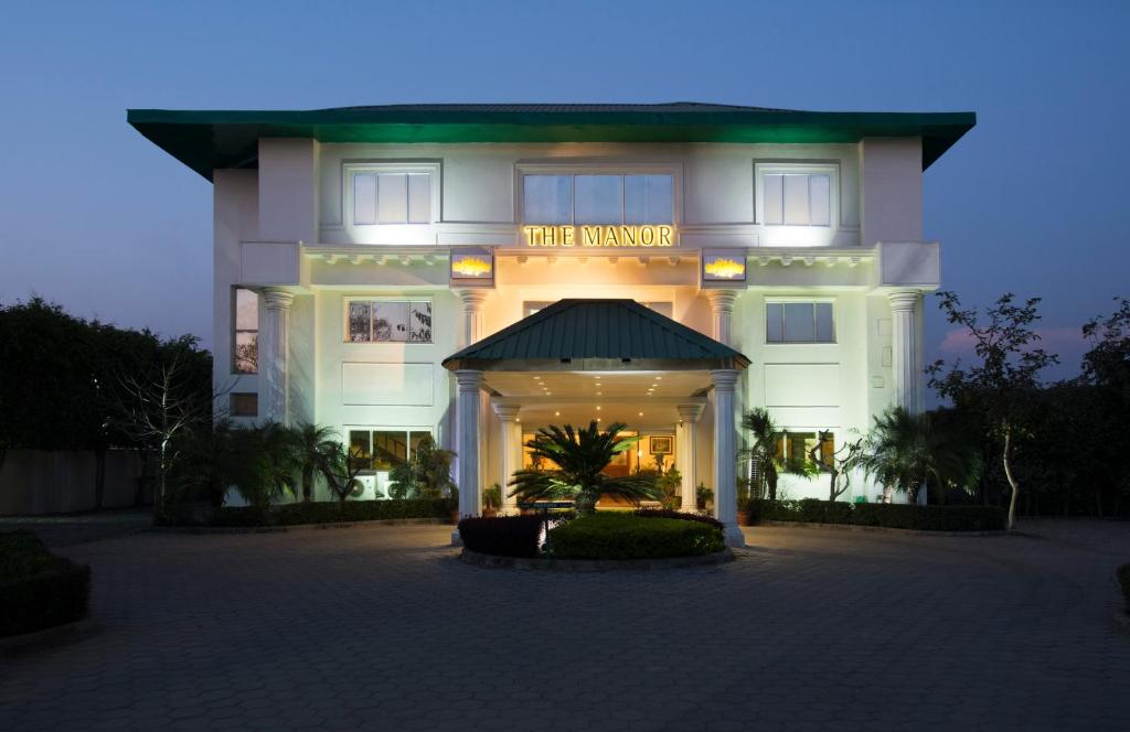un bâtiment avec un panneau qui lit le manoir dans l'établissement The Manor Kashipur by Leisure Hotels, à Kāshīpur