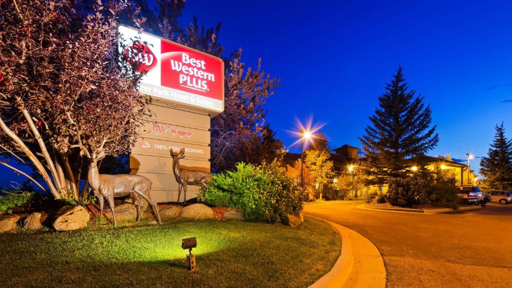 una señal para un restaurante con dos estatuas de ciervo delante de él en Best Western Plus Deer Park Hotel and Suites en Craig