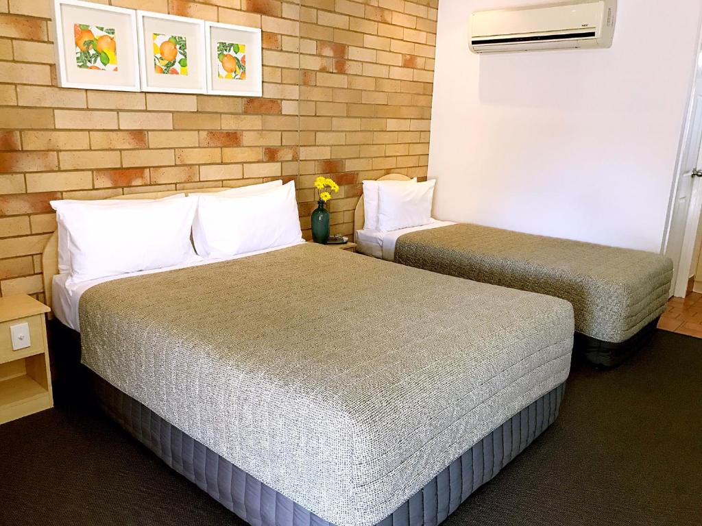 two beds in a hotel room with two at Starlight Motor Inn in Roma