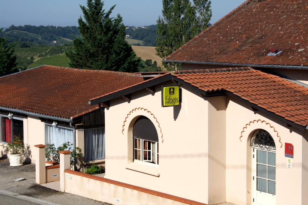 a small white building with a sign on it at Logis des Crêtes de Pignols in Moissac