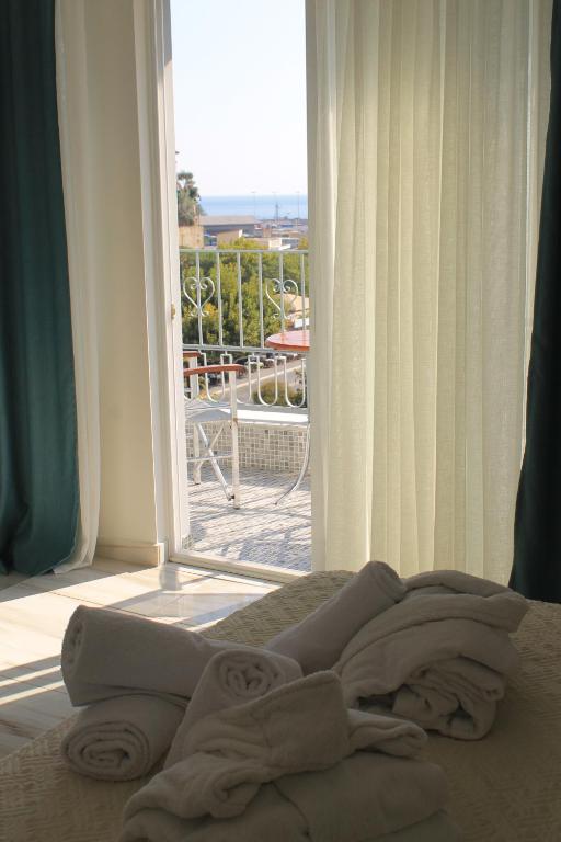 a bed in a room with a large window at Castello Boutique Rooms in Kavála