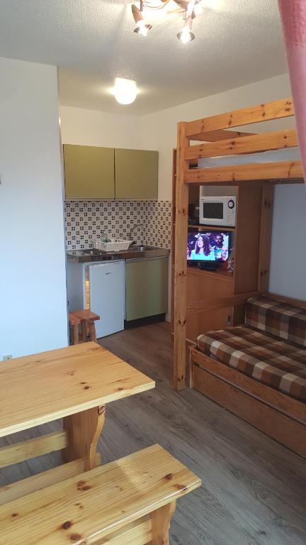 ein Wohnzimmer mit einem Etagenbett und eine Küche in der Unterkunft Studio Champerouze 127 in La Toussuire