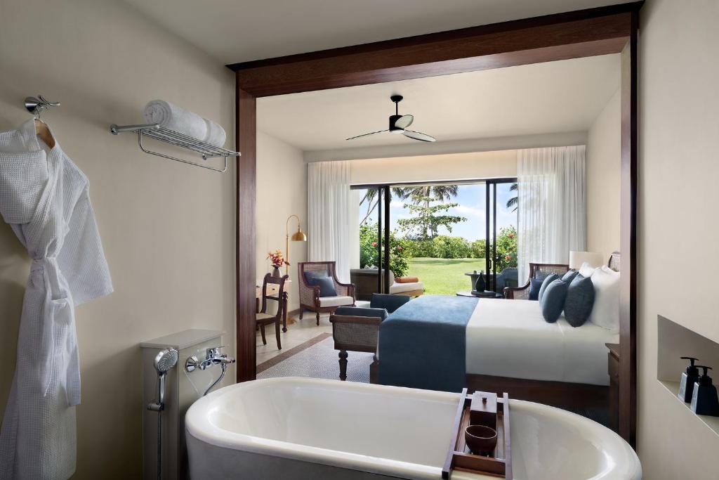 a bathroom with a bed and a tub and a bedroom at Anantara Peace Haven Tangalle Resort in Tangalle