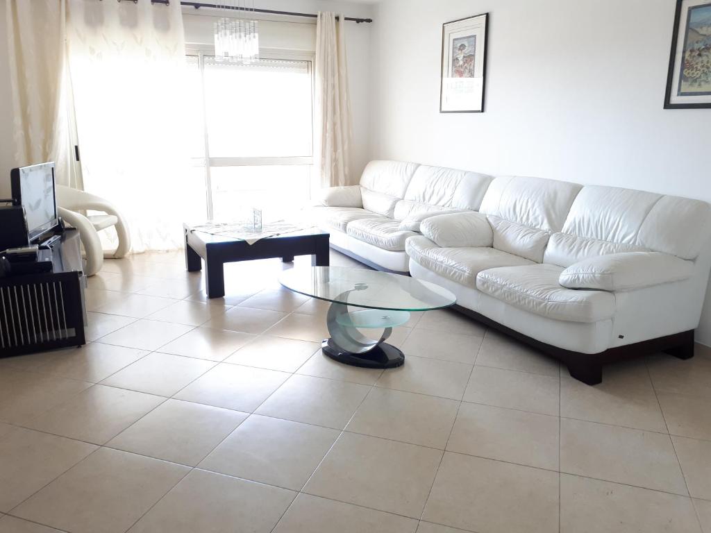 uma sala de estar com um sofá branco e uma mesa em Shoam street apartment sea view Ashdod em Ashdod