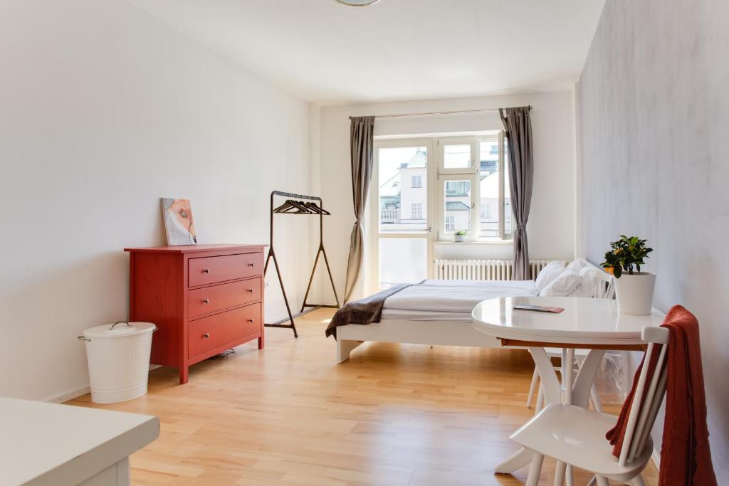 a bedroom with a bed and a table and a window at JT's Apartments Opletalova str. in Prague