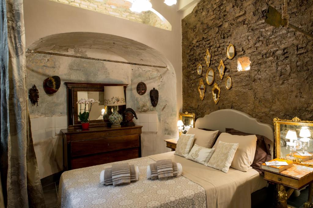sypialnia z łóżkiem i kamienną ścianą w obiekcie L'8 Boutique Design Apartments w Bolonii