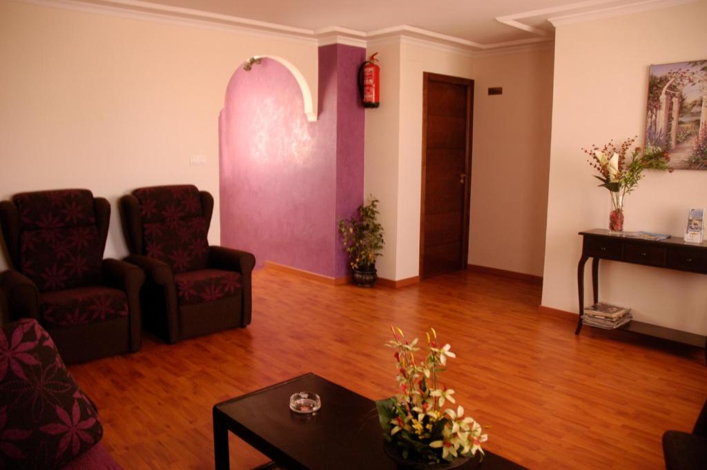 ein Wohnzimmer mit 2 Stühlen und einem Tisch in der Unterkunft Hostal Cabrera in Motril