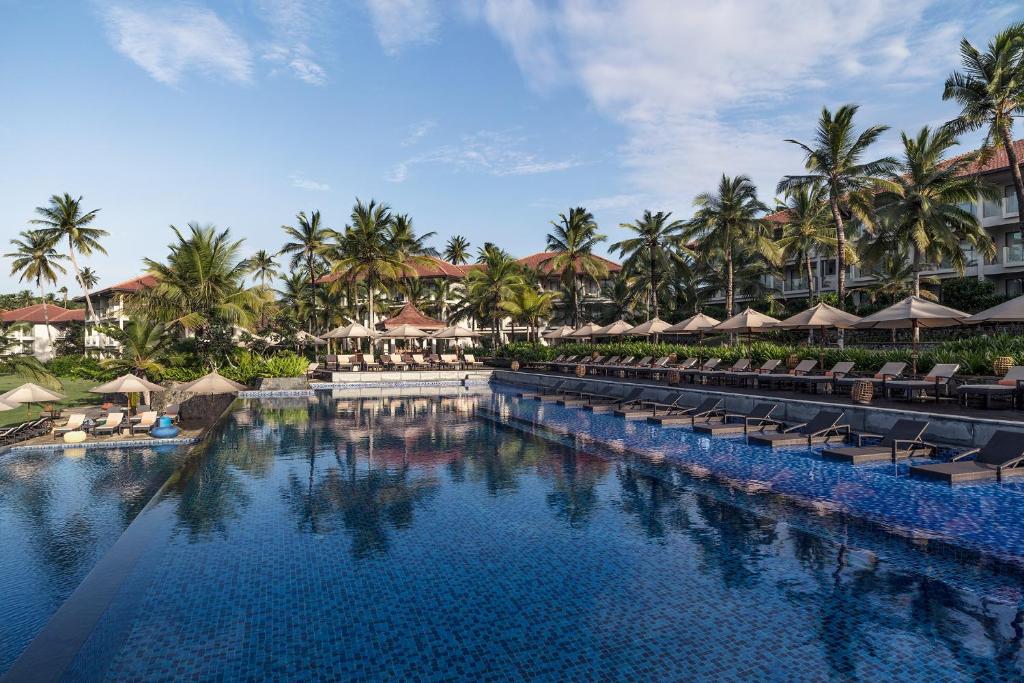 a pool at a resort with chairs and umbrellas at Anantara Peace Haven Tangalle Resort in Tangalle