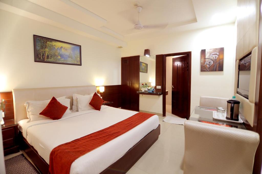 Habitación de hotel con cama y silla en Taj Inn Hotel, en Agra