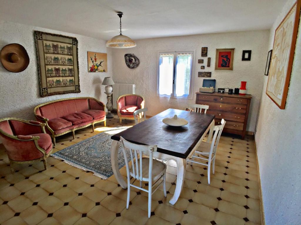 un soggiorno con tavolo, sedie e divano di Appartamento in campagna con ampio terrazzo a Roatto