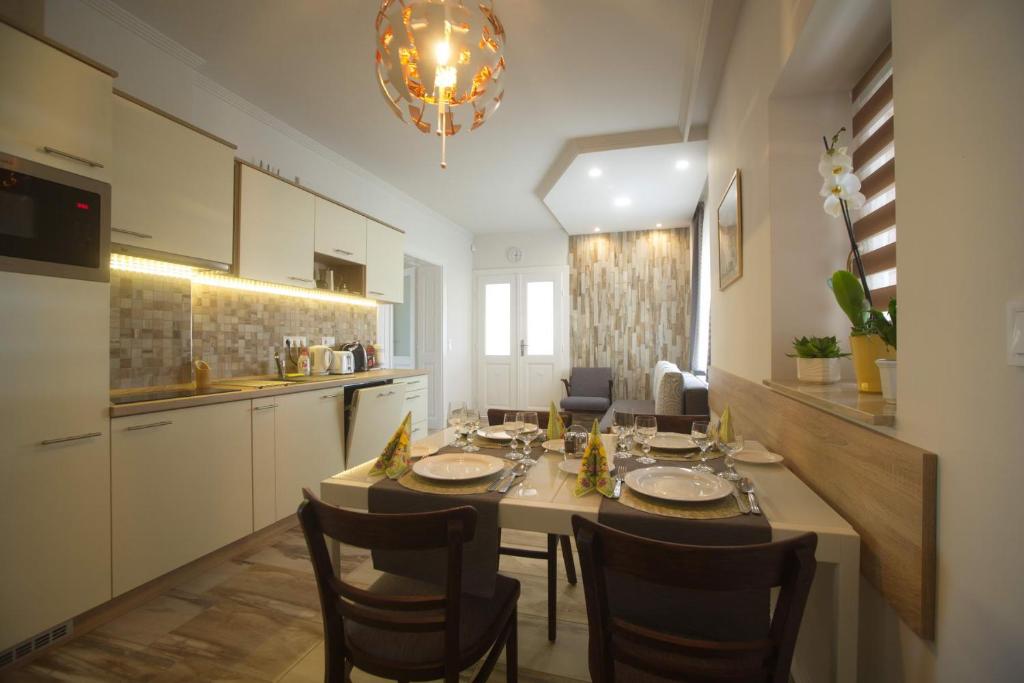 a kitchen with a table with chairs and a dining room at Holiday Home Podium in Eger