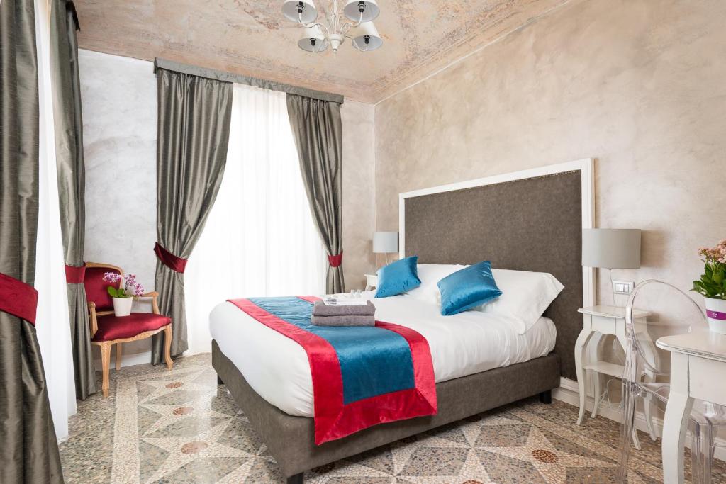 都靈的住宿－塞利阿住宿加早餐旅館，一间卧室配有一张带蓝色和红色枕头的大床