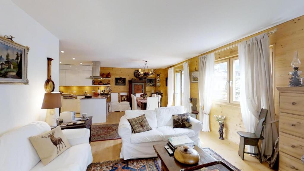 Il comprend un salon avec un mobilier blanc et une cuisine. dans l'établissement Demont 3, à Celerina