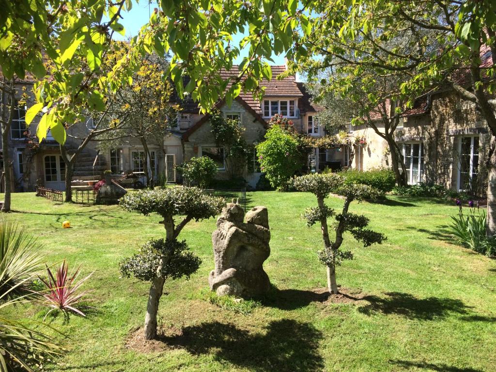 uma estátua no quintal de uma casa com árvores em Domaine saint-martin d Amfreville em Amfréville
