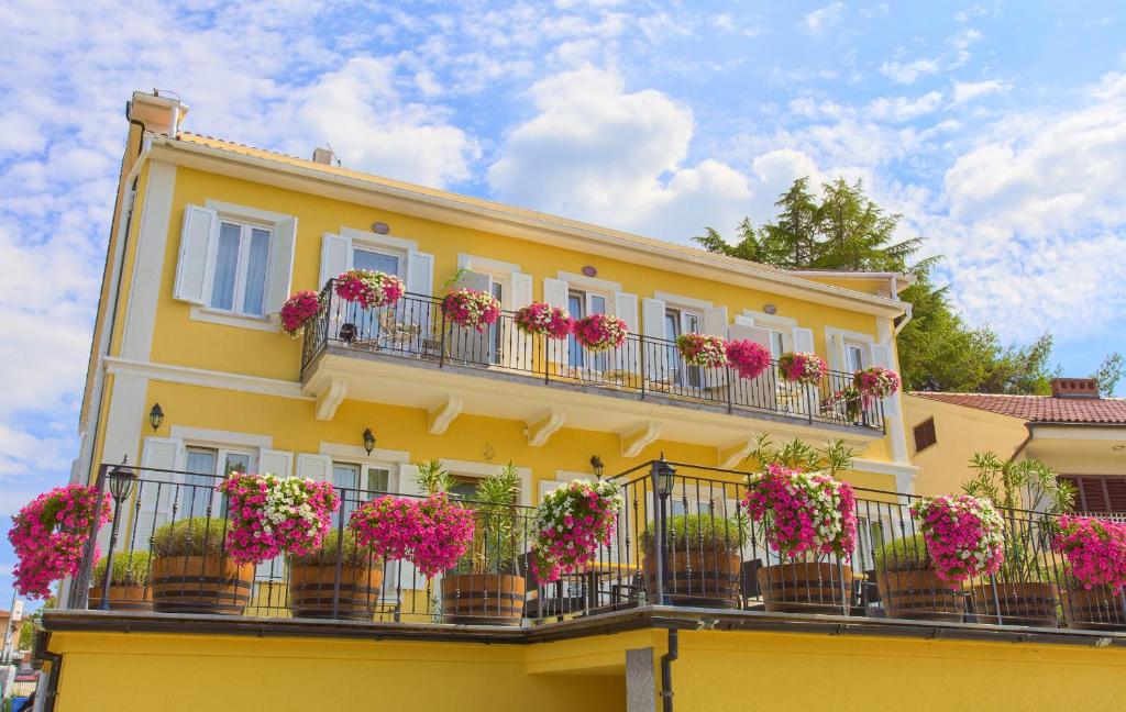 a yellow building with flower boxes on its balconies at Frajona Apartments in Malinska