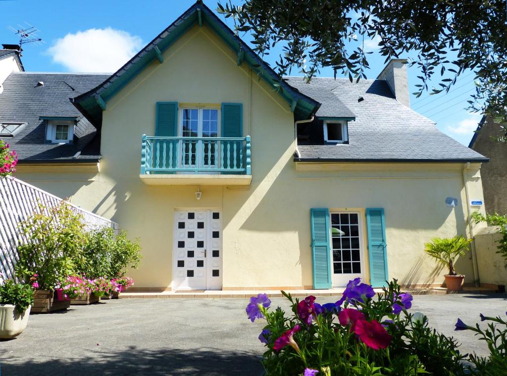 una casa con balcone e fiori di fronte di En so de Bourdet a Lourdes