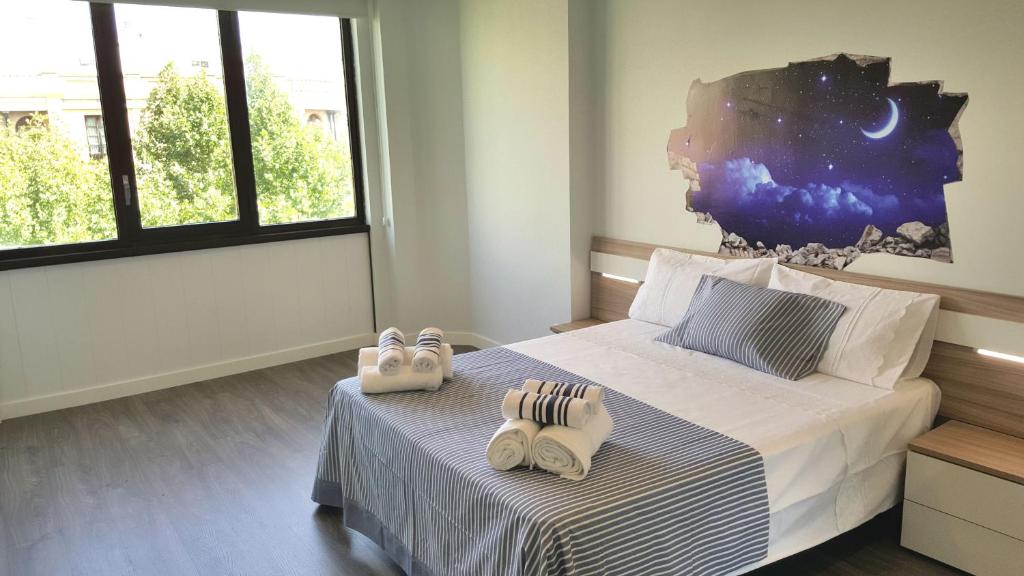 a bedroom with two pairs of slippers on a bed at Apartamento Boulevard Gran Capitan by JITKey in Córdoba