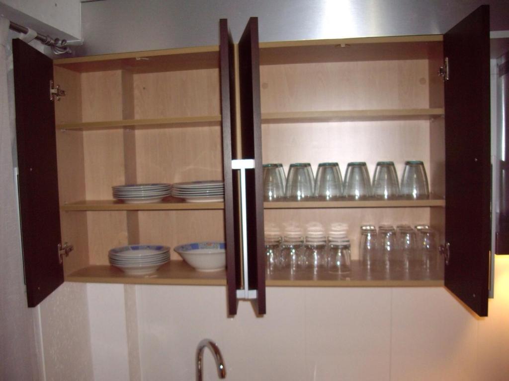 バレンシアにあるApartamentos Artesのキッチン用の食器棚(皿、グラス付)