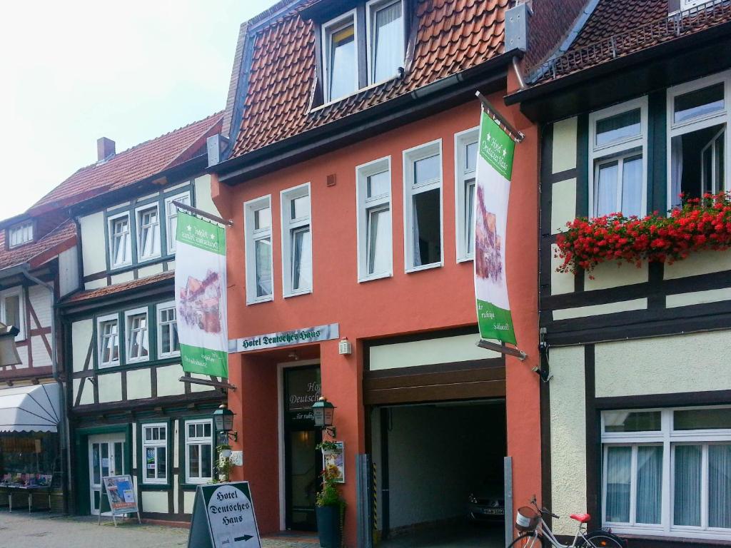 un grupo de edificios en una calle con flores en Hotel Deutsches Haus en Northeim