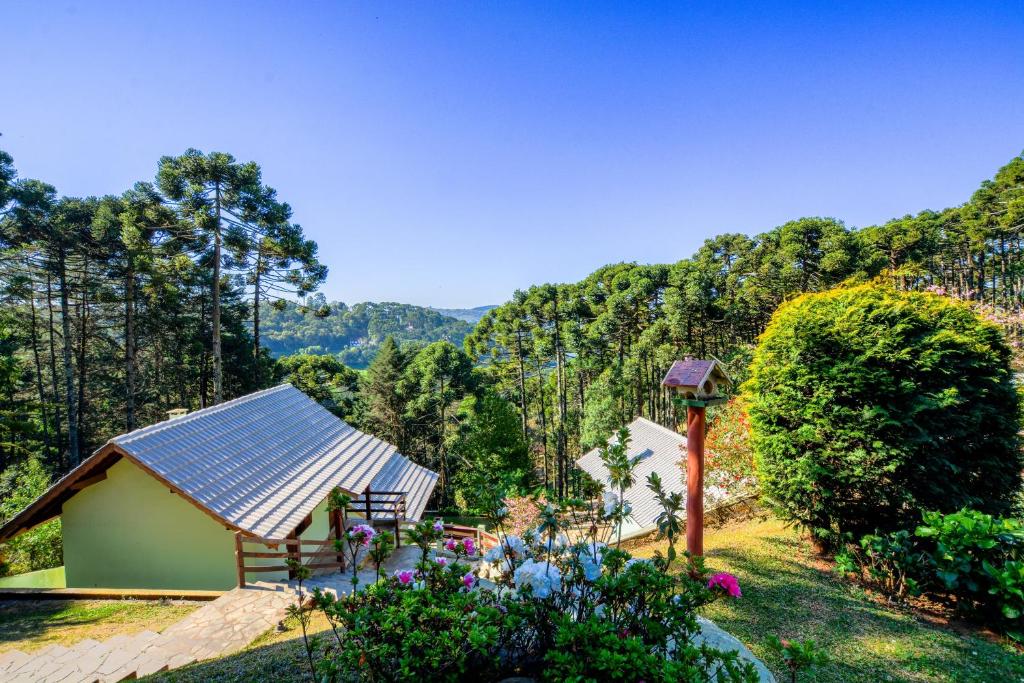 a house with a solar roof with a garden at Pousada Ágape in Monte Verde