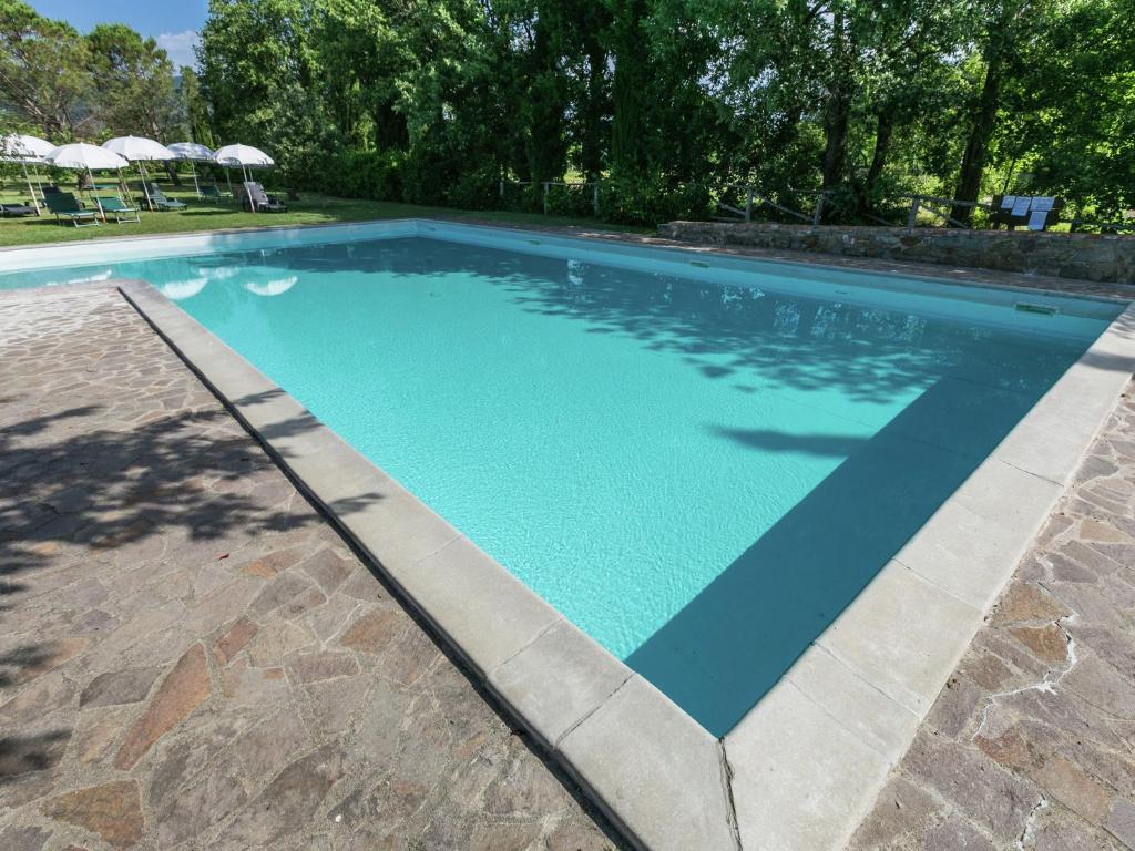a large swimming pool with a blue at Belvilla by OYO San Martino in Ambra