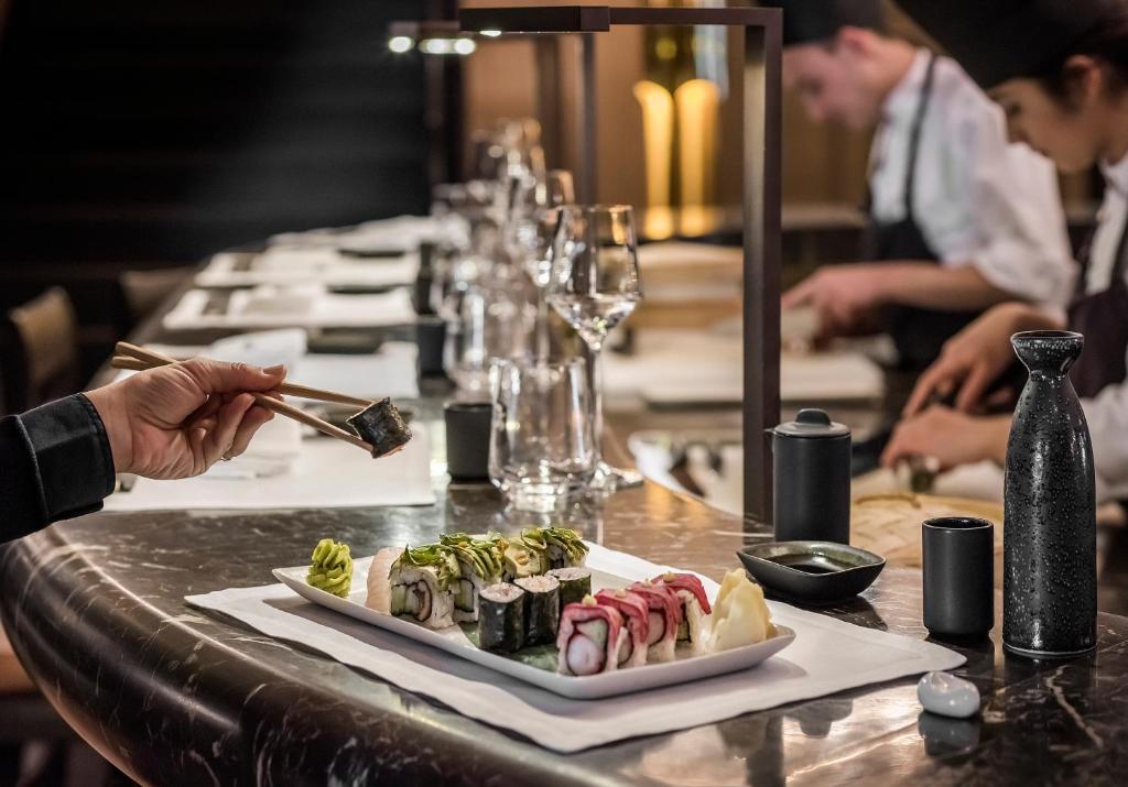 a table with a plate of sushi and chopsticks at Apogée Courchevel, Oetker Hotels in Courchevel