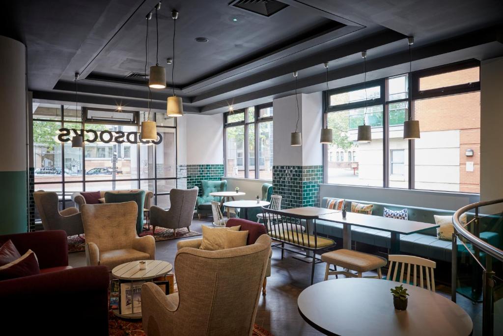 a restaurant with chairs and tables and windows at Leonardo Hotel Manchester Central in Manchester