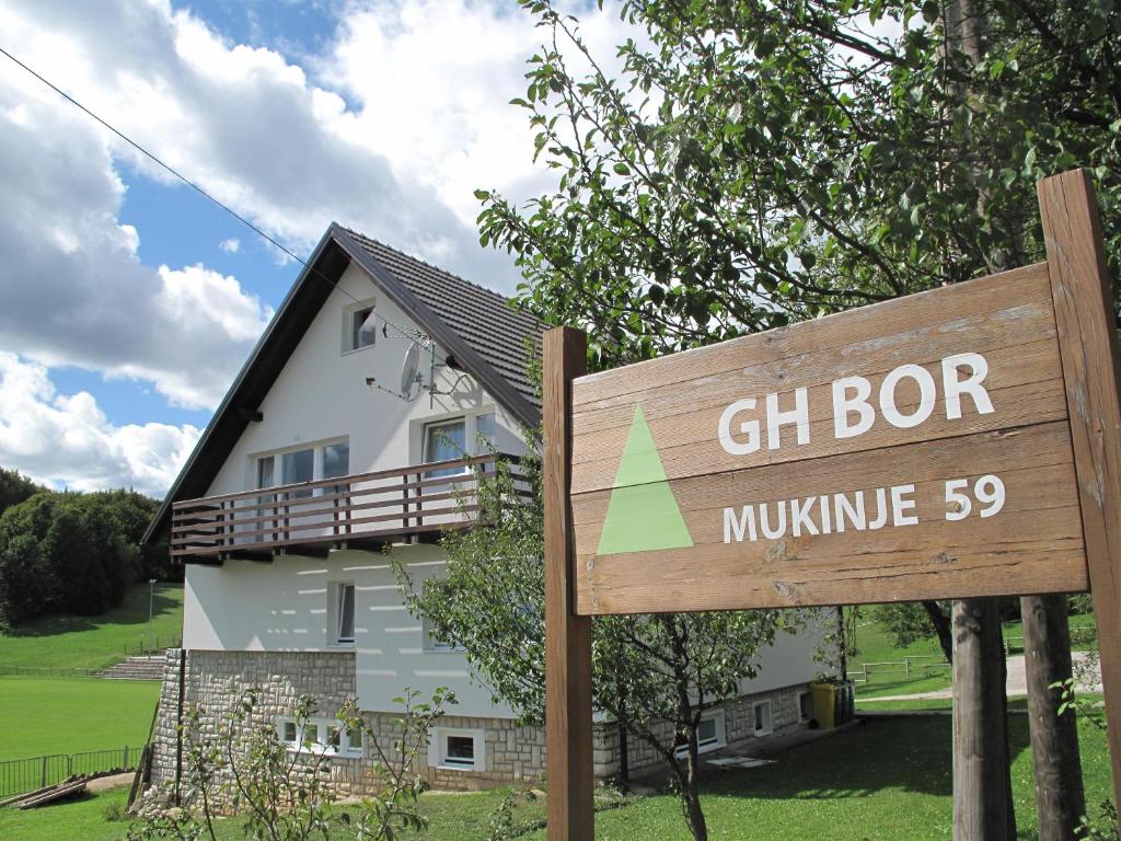 una señal frente a una casa con un edificio en Guesthouse Bor Plitvice Lakes en Plitvička Jezera