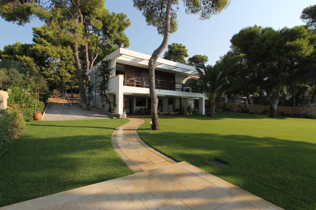a house with a walkway in front of a yard at Villa Pebbles in Agioi Theodoroi