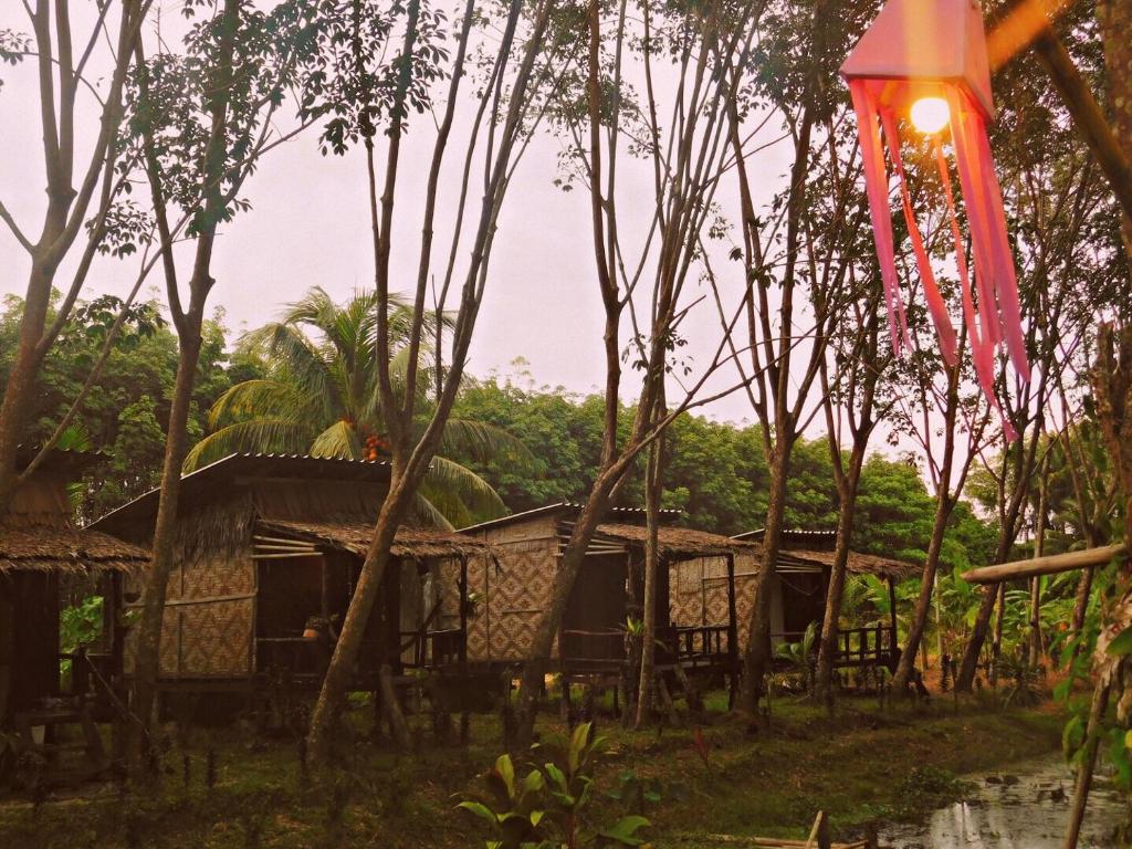 a group of houses in a forest with a red flag at Easylife Bungalow in Ko Lanta