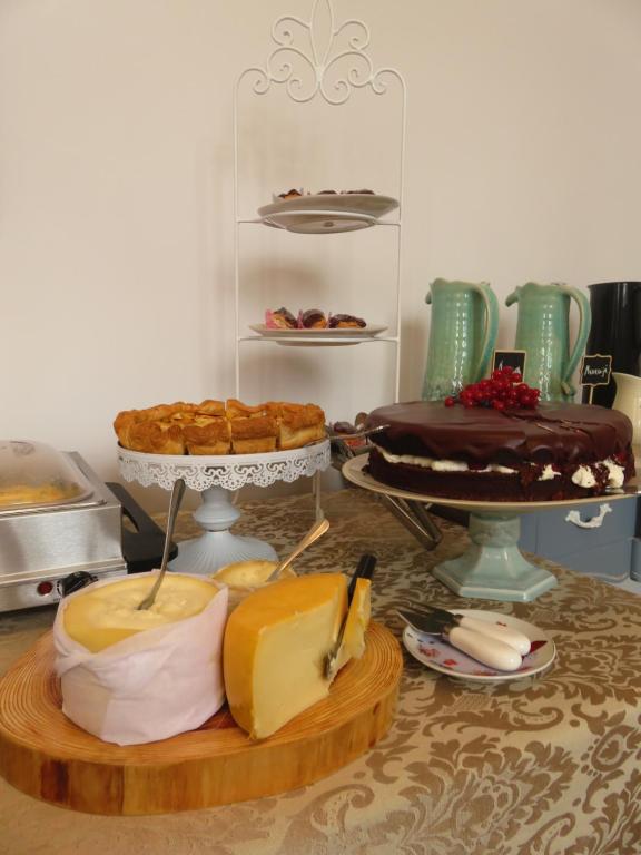 a table topped with lots of different types of cakes at Casa das Palmeiras Charming House - Azores 1901 in Ponta Delgada