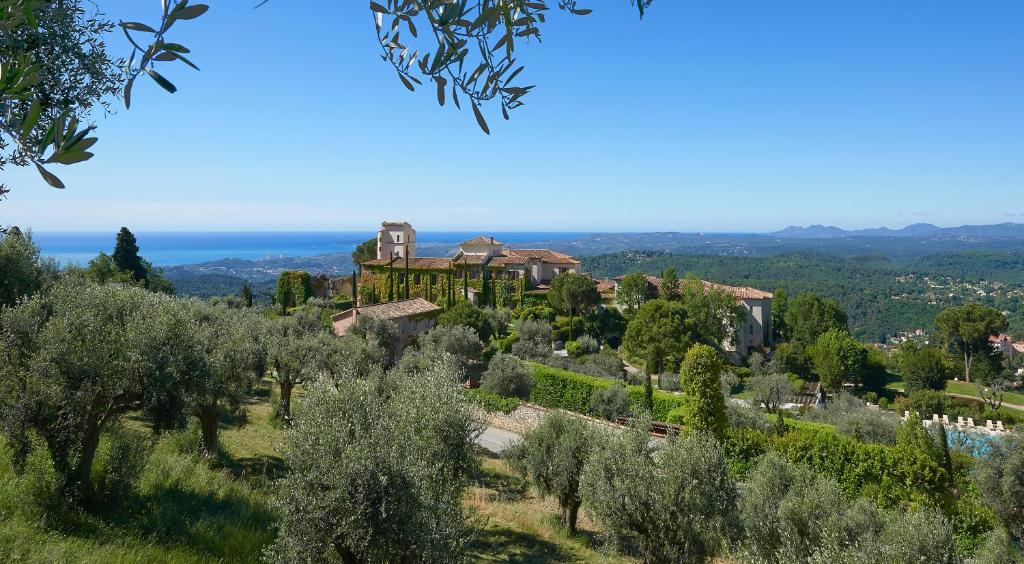 a villa on top of a hill with trees at Château Saint-Martin & Spa - an Oetker Collection Hotel in Vence