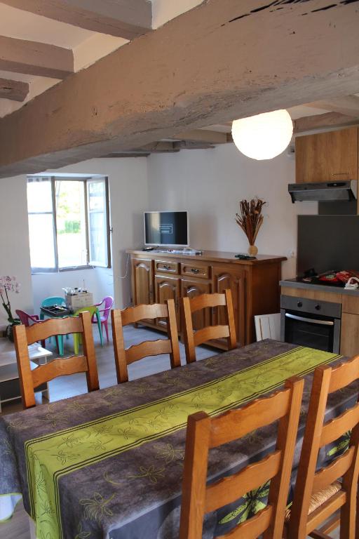 a kitchen and dining room with a table and chairs at Un petit coin de paradis in Champigny-sur-Veude