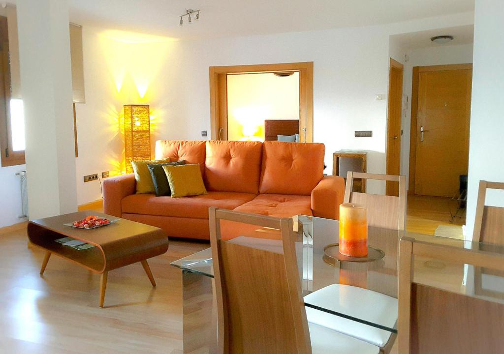 sala de estar con sofá naranja y mesa en Cangas Plaza, en Cangas de Onís
