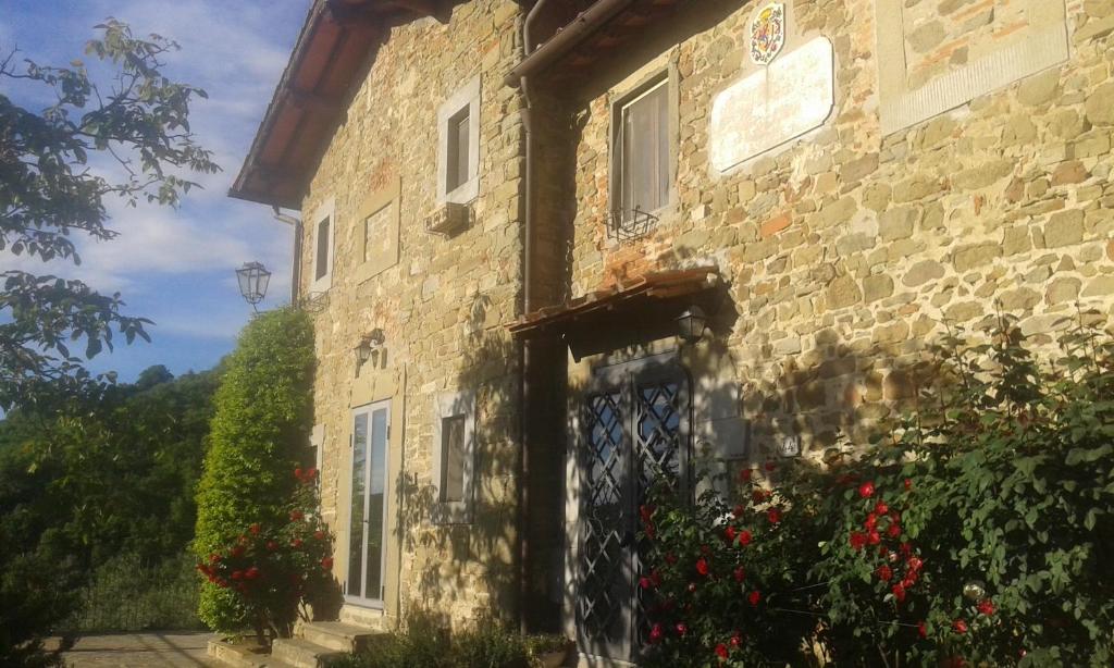 un antiguo edificio de piedra con una puerta y flores en Country house near Florence en Florencia