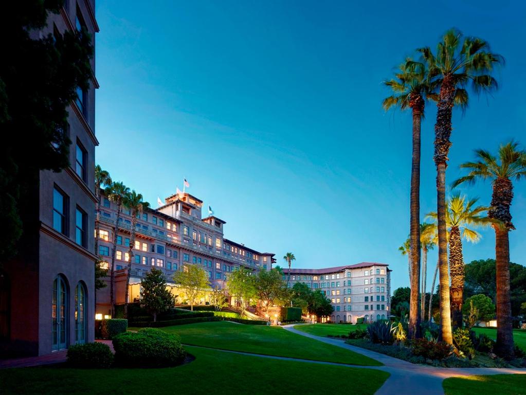 a large building with palm trees and palm trees at The Langham Huntington, Pasadena in Pasadena