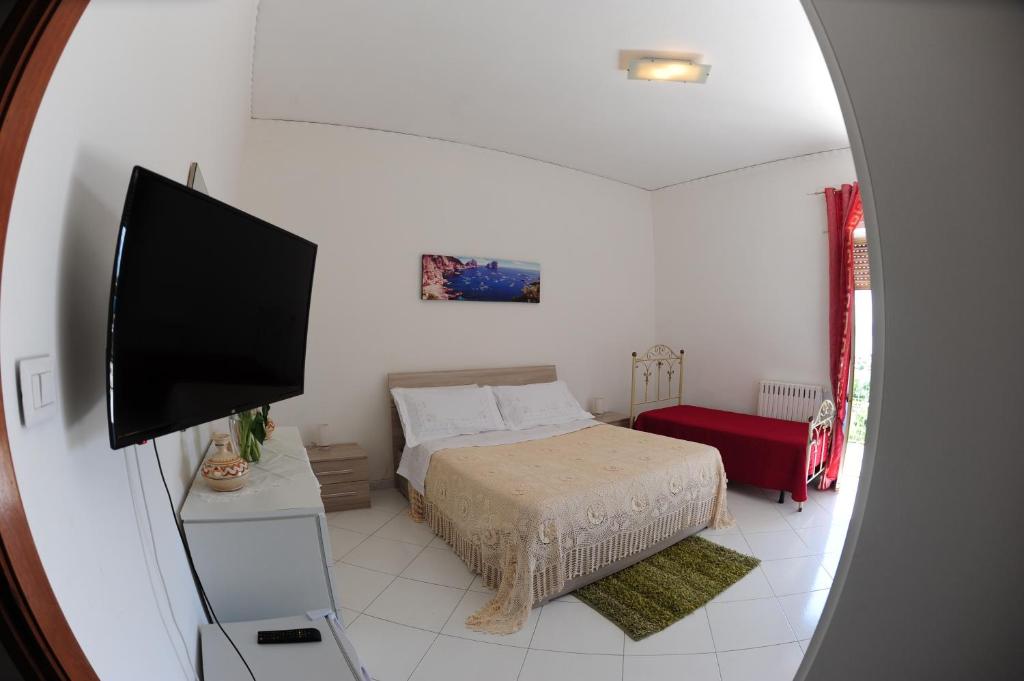 a bedroom with a bed and a flat screen tv at The Last Floor in Torre del Greco